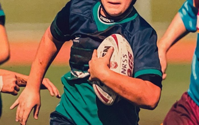 Young rugby player running with ball