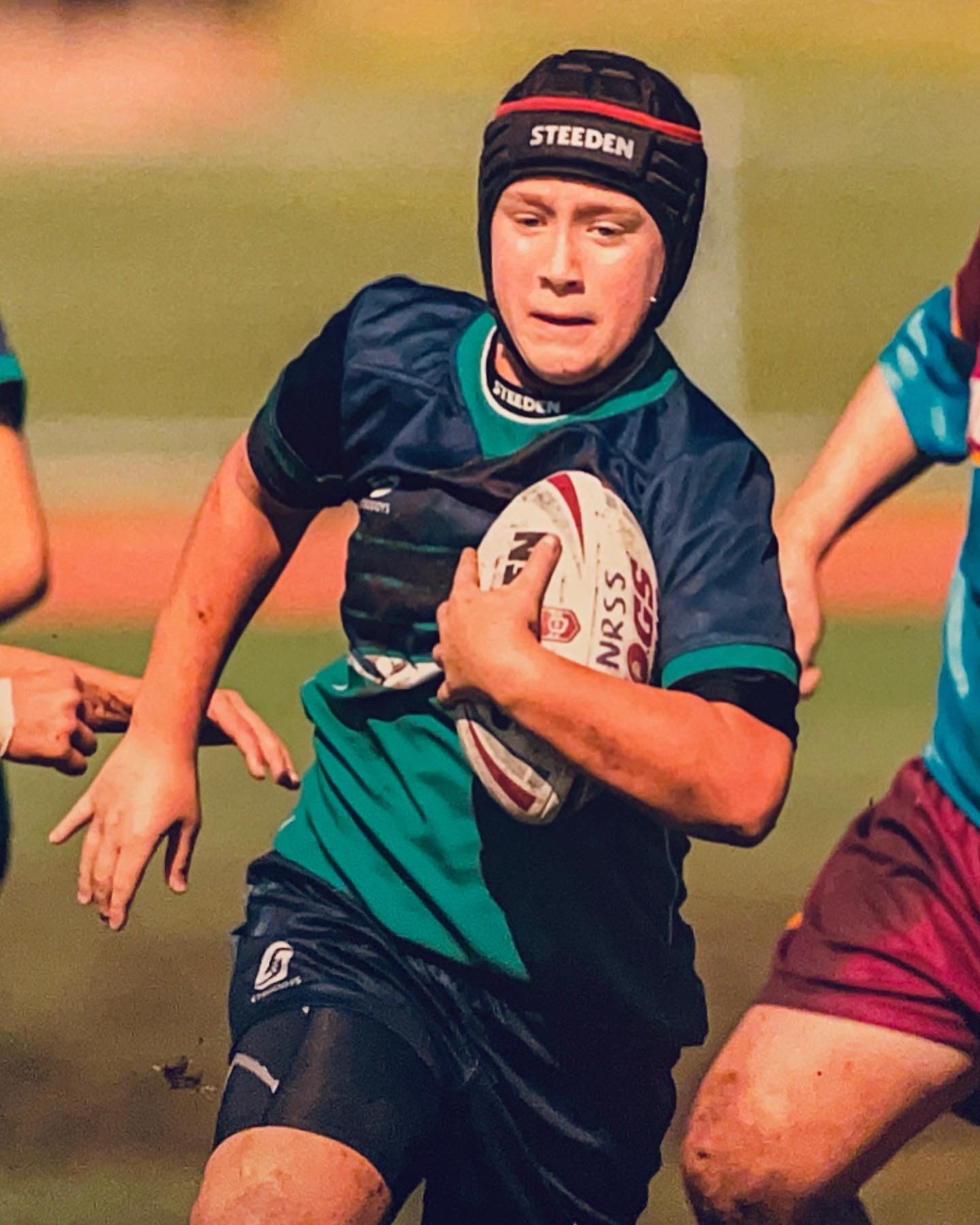 Young rugby player running with ball