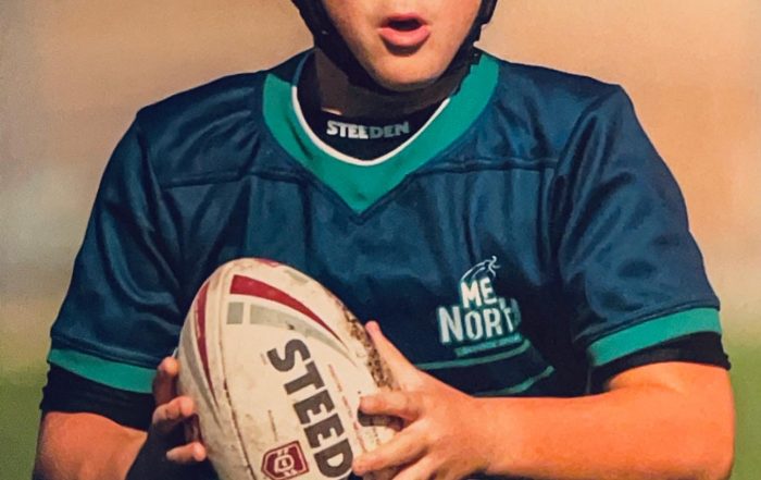 young rugby player runs with the ball